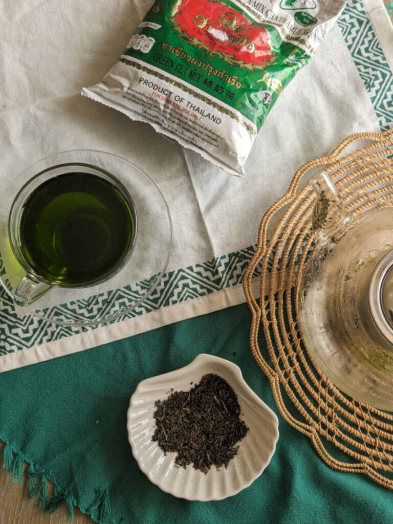cha tra mue jasmine green tea bag next to a cup of cha tra mue jasmine green tea