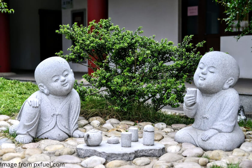 Statue of two Buddhist monks enjoying tea; history of tea was closely tied to the spread of Buddhism