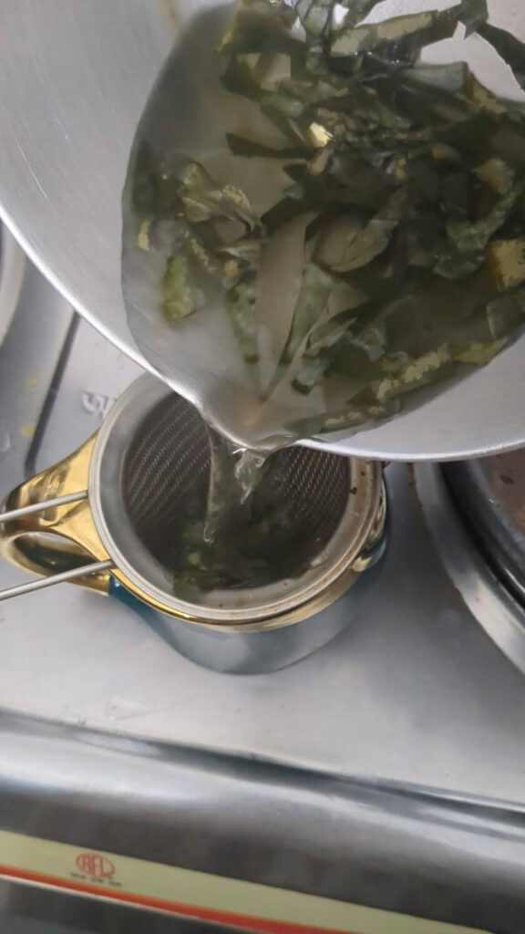 Final step in  how to make tea from soursop leaves: pour tea over strainer and enjoy